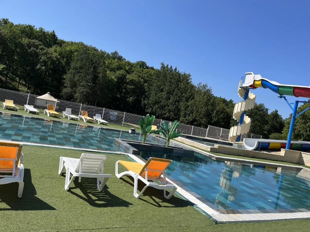 a swimming pool with chairs and a water slide at Camping 3 étoiles - Piscine - ccbfa0c in Saint-Mandé-sur-Brédoire
