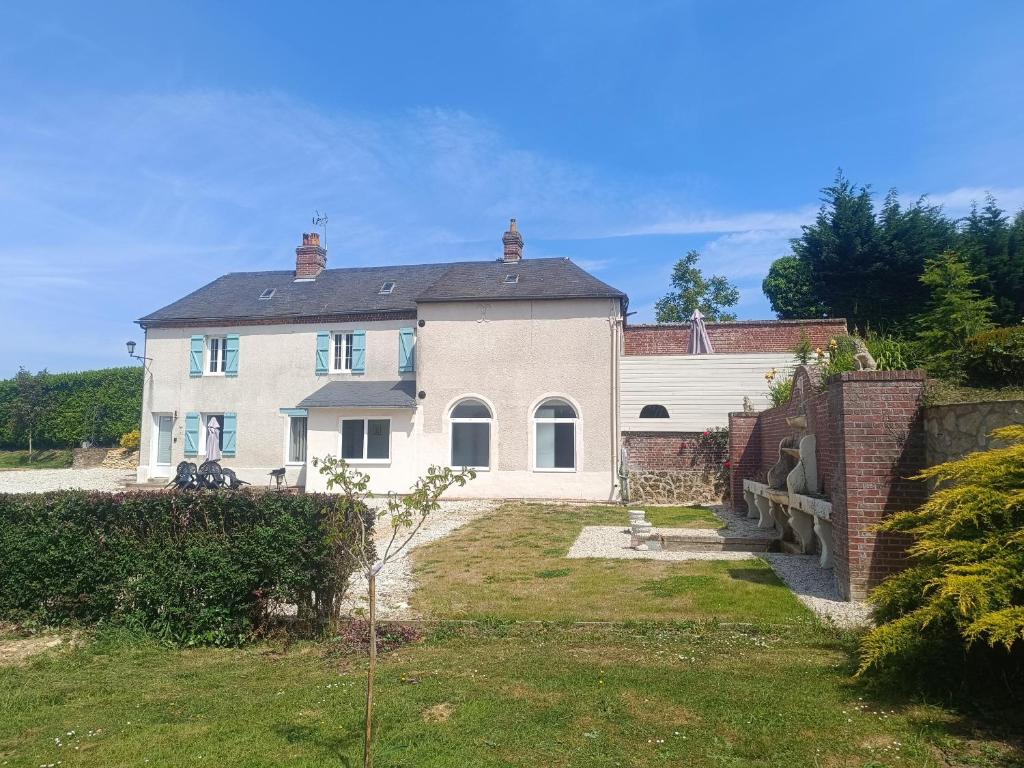 a large white house with a brick fence at domaine des trois rivières in Sainte-Marguerite-de-Viette