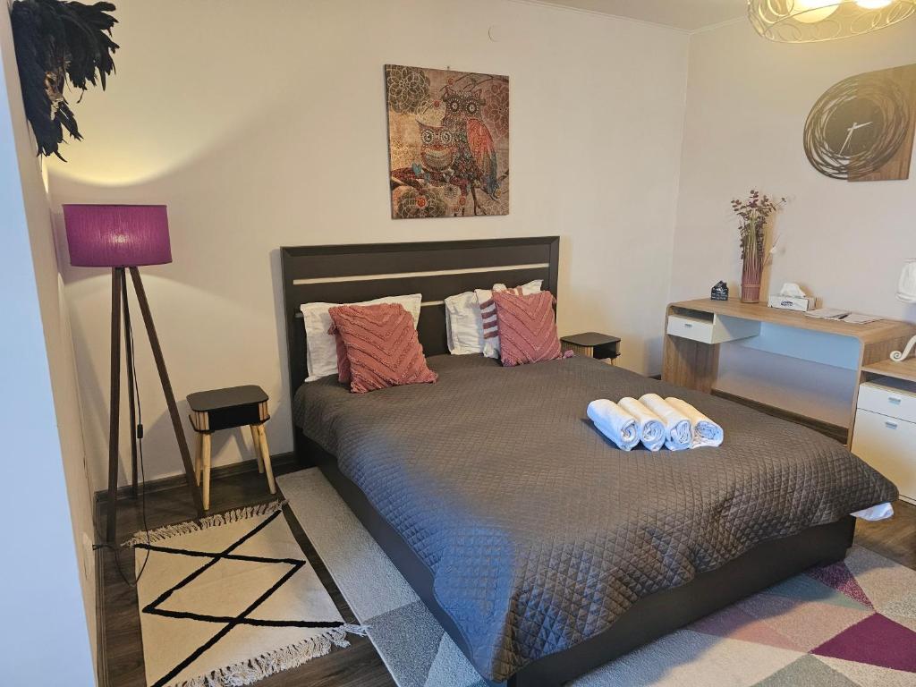 a bedroom with a bed with two pillows and a desk at Stone Bridge Studio in Iaşi