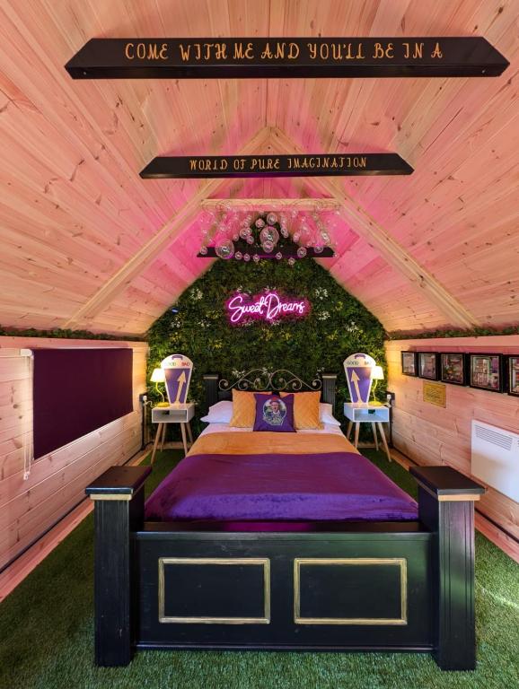 a bedroom with a bed with two chairs and a sign at Kits Coty Glamping in Maidstone