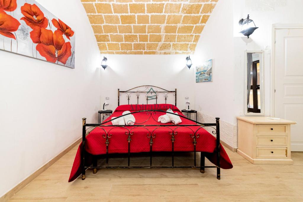 a bedroom with a red bed with a red blanket at Casa di Levante - Gallipoli in Gallipoli