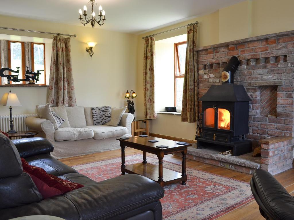 a living room with a couch and a fireplace at Bings Farm House in Whaley Bridge