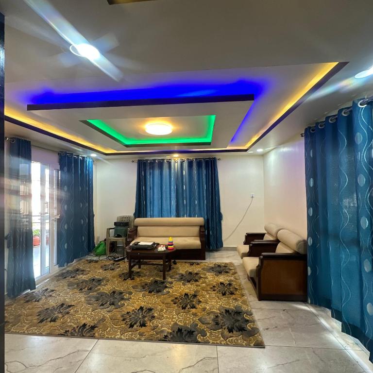a living room with a couch and a blue ceiling at A Cube Homestay in Bharatpur