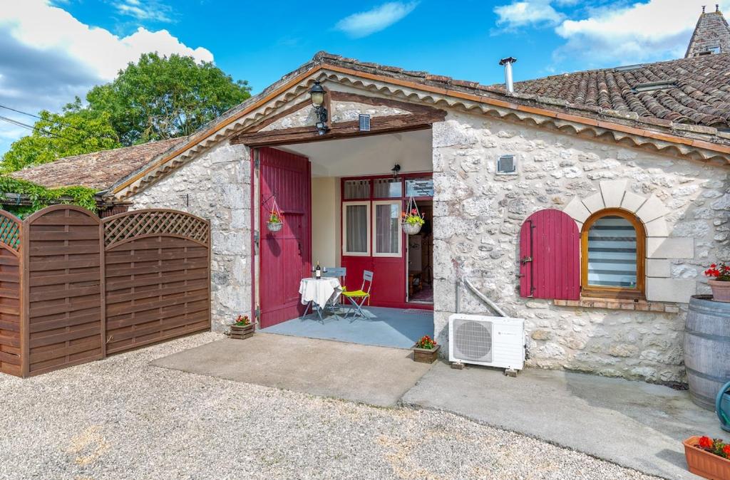 a house with a red door and a patio at Private gîte with stunning views & shared pool in Laussou