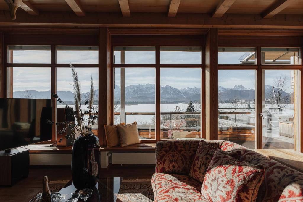 a living room with a couch and a large window at Luxus Seaside Loft in Füssen