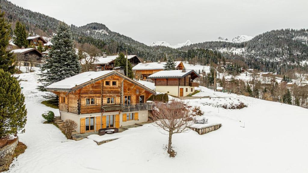 a large wooden house in the snow at Atalaya Chalet - Panoramic View in Saint-Jean-de-Sixt