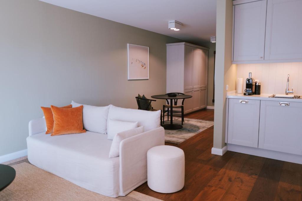 a living room with a white couch and a table at Sünn un See - Hortensienblick in Ahrenshoop