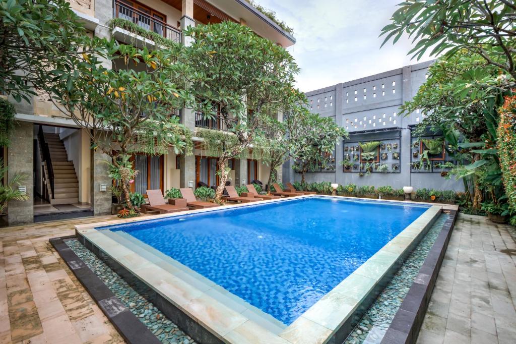 a swimming pool in the courtyard of a building at D Sarian Seminyak in Seminyak