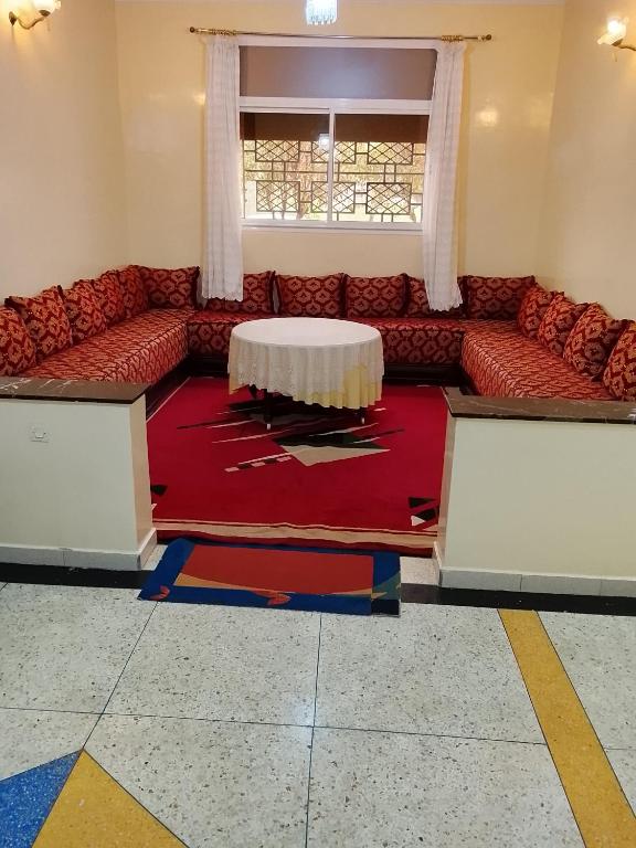 a living room with a red couch and a table at Razzak in Rabat