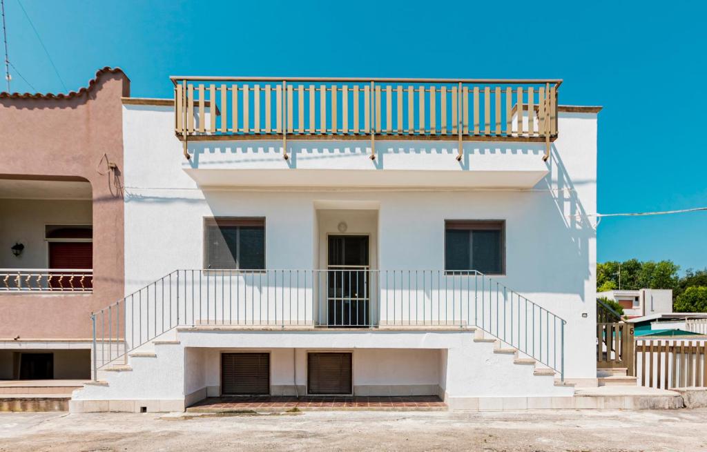 a white building with a balcony on top of it at Villetta Degli Aranci in San Foca