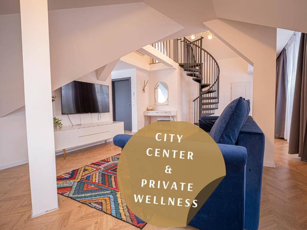 a living room with a blue couch and a tv at Apartmány Harmony Liptov - City Center & Private Wellness in Liptovský Mikuláš