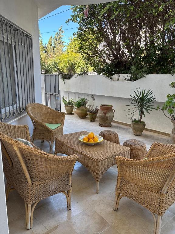 a patio with chairs and a table with oranges on it at Maison casa bloom - La marsa in Bin Rhilouf