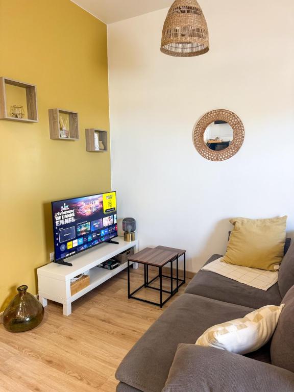 a living room with a couch and a flat screen tv at Cozy Studio with Terrace in Cers
