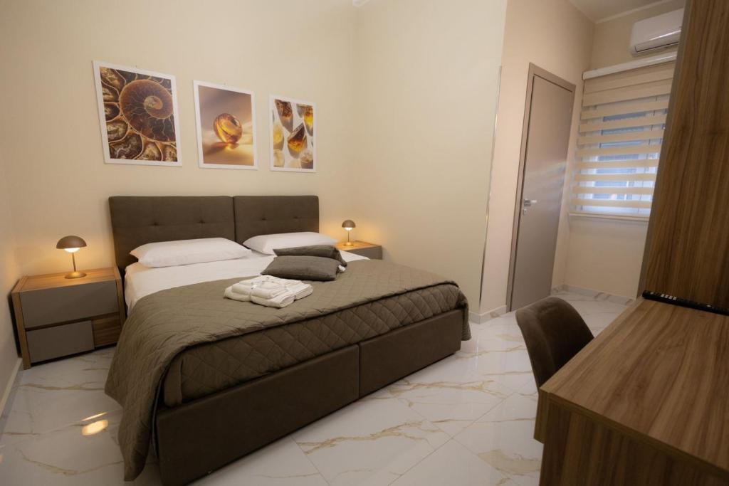 ein Schlafzimmer mit einem Bett, zwei Tischen und zwei Lampen in der Unterkunft GioielliPlace in Capodrise