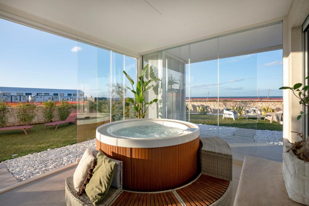 a hot tub in a living room with a large window at Villa fronte mare in Bari