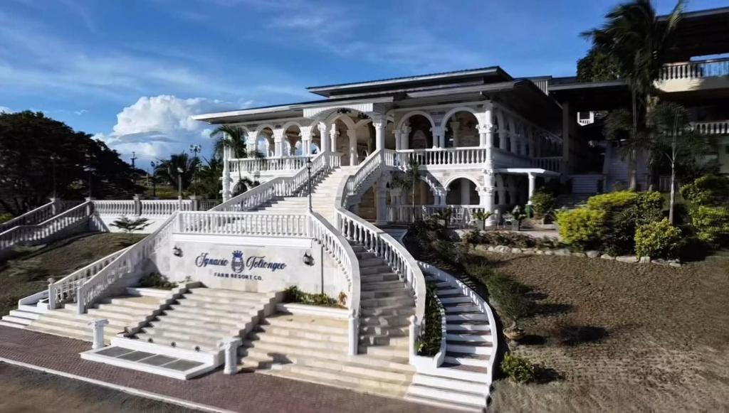 a large white house with stairs in front of it at IT Farm Resort in Rizal