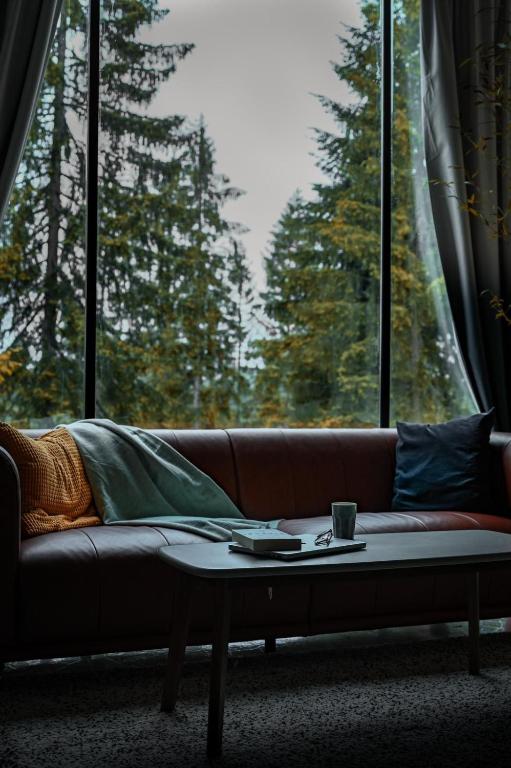 a couch with a coffee table in front of a window at ZlatAir Twins 2 in Nova Varoš