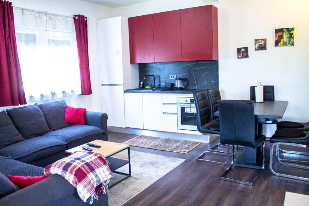 a living room with a couch and a kitchen at Apartman Gajnice Zagreb in Zagreb