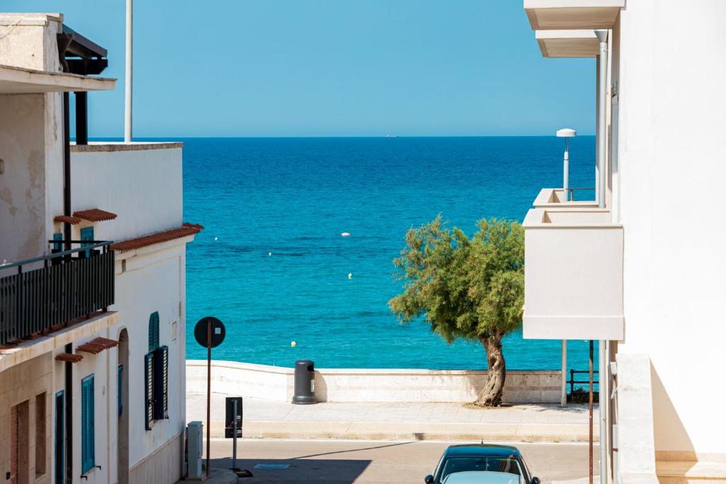 a view of the ocean from between two buildings at Il Bacio del Sole - San Foca in San Foca