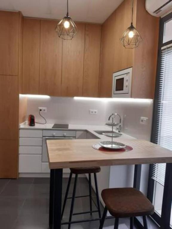 a kitchen with a sink and a counter with two stools at LOFT La Placeta in Enguera