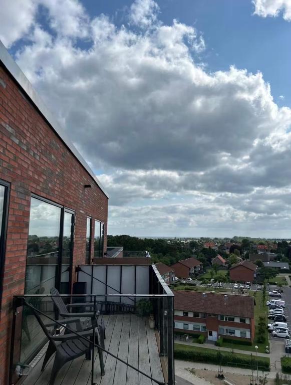 a balcony with a bench on top of a brick building at Beach View Apartment in Vallensbæk in Vallensbæk