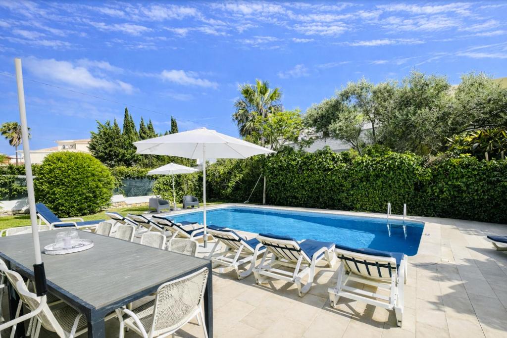 a patio with a table and chairs and a pool at Strip - Private Pool - 12 Guests - Albufeira in Albufeira