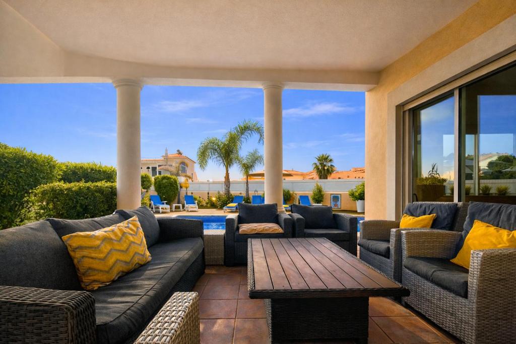 a patio with couches and a table and a pool at Sunshine - Private Pool - 8 Guests - Albufeira in Albufeira