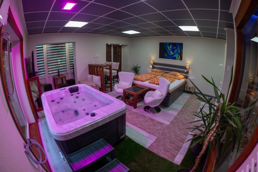 a room with a tub and a bedroom with a bed at E14 apartman in Berekfürdő