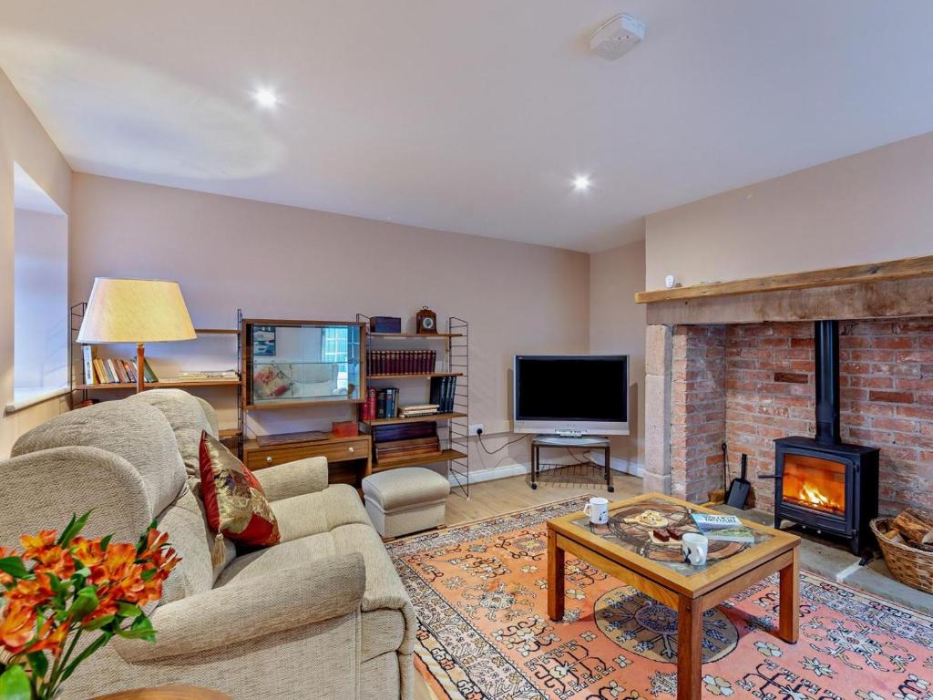 a living room with a couch and a fireplace at 1 Bed in Alnwick oc-95776 in Chillingham