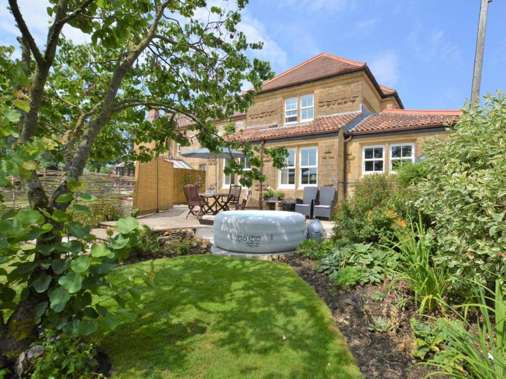 a garden with a bath tub in front of a house at 2 Bed in Dorchester oc-59666 in Long Bredy