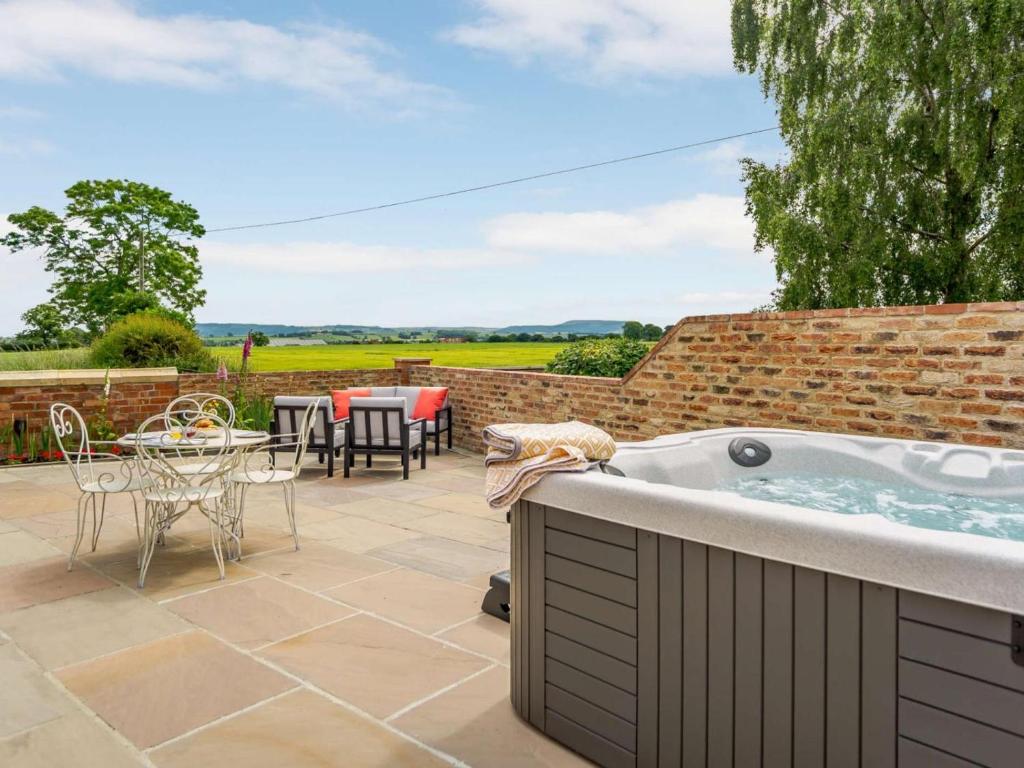 a hot tub on a patio with a table and chairs at 2 Bed in Northallerton oc-83398 in Brompton