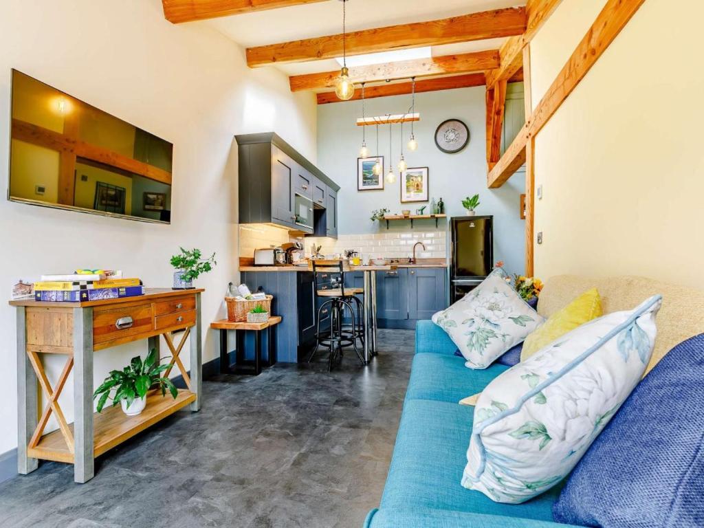 a living room with a blue couch and a kitchen at 1 Bed in Ripon oc-85511 in Masham