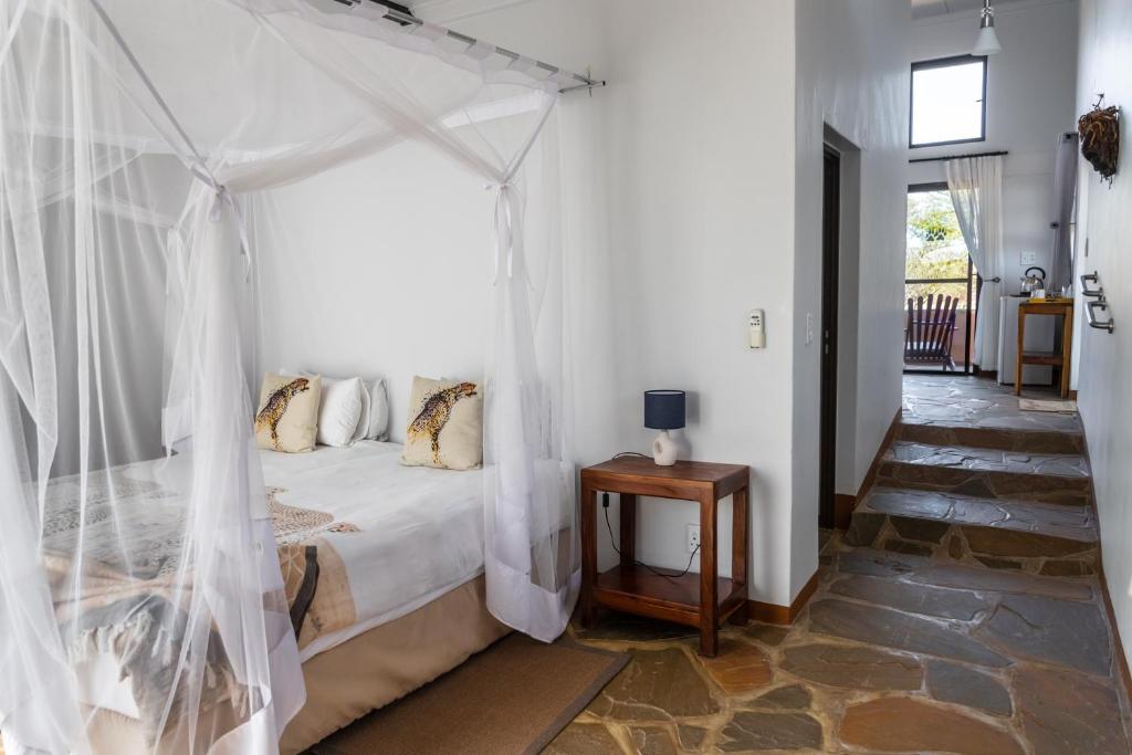 a bedroom with a bed with a canopy at Cheetah View Lodge at Cheetah Conservation Fund in Otjiwarongo