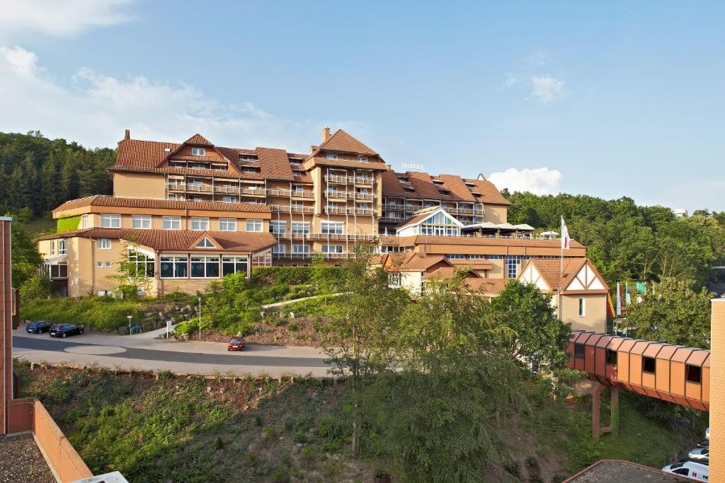 ein großes Gebäude auf einem Hügel mit einem Zug in der Unterkunft Göbels Hotel Rodenberg in Rotenburg an der Fulda