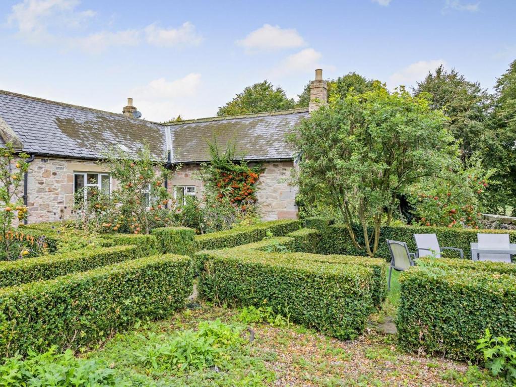 an old stone house with a garden in front of it at 3 Bed in Cornhill -on- Tweed oc-76374 in Carham