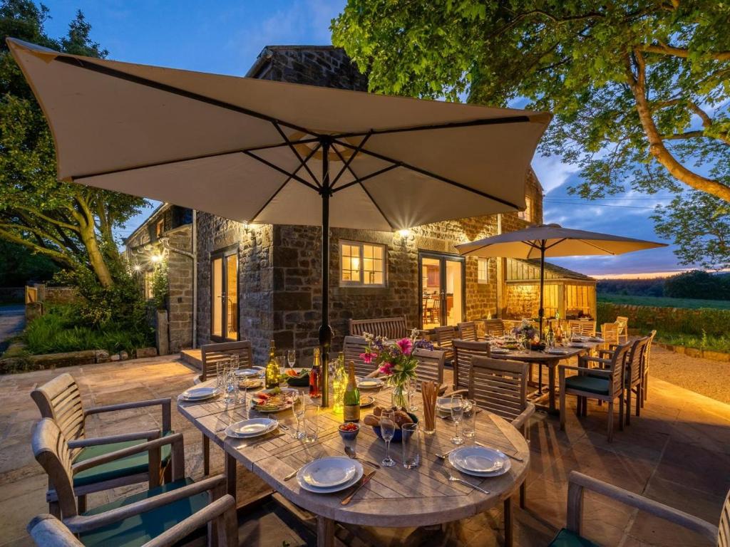an outdoor dining area with tables and umbrellas at 8 Bed in Ripon oc-72263 in Grantley