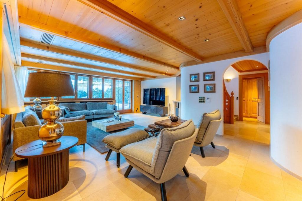 a living room filled with furniture and a wooden ceiling at Chalet Eclipse, The Hidden Wonder in Hornkessel
