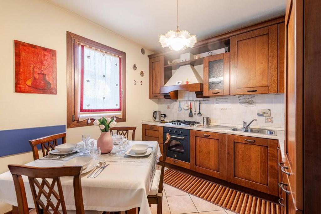 a kitchen with a table and chairs and a kitchen with a sink at La tua casa meravigliosa con giardino in Fontanafredda