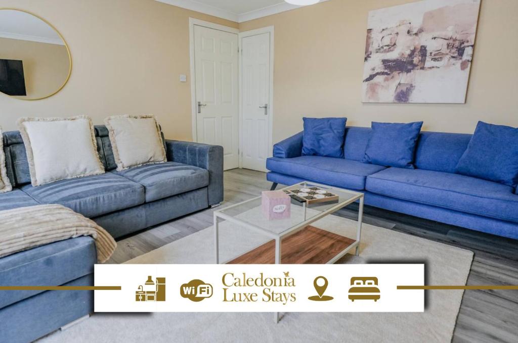 a living room with blue couches and a table at Dunward House in Livingston