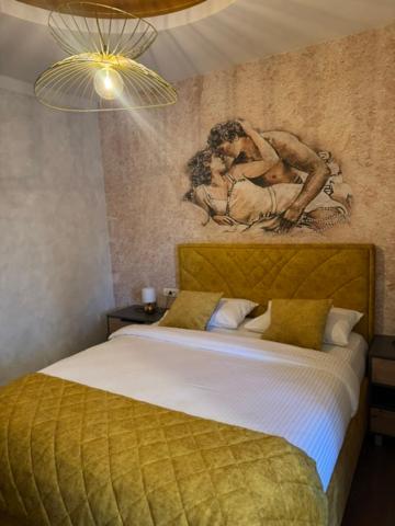 a bedroom with a bed with a painting on the wall at Pansion Afitos in Laktaši