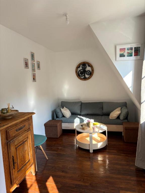 a living room with a couch and a table at Séjour idyllique normand - Appartement cosy à 5 min de la plage - Veules-les-Roses in Veules-les-Roses