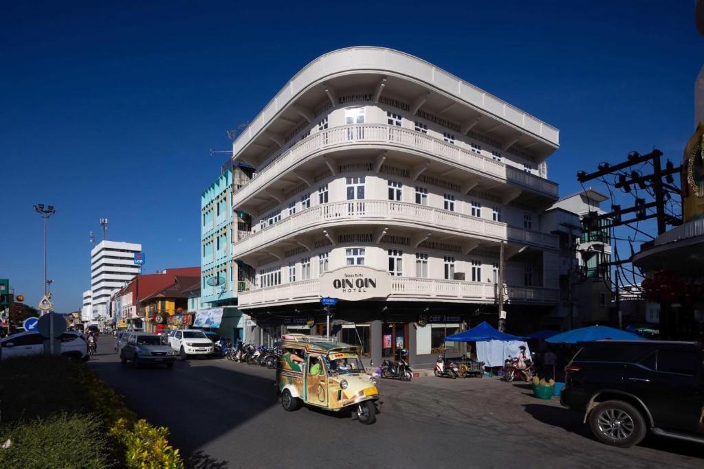 a yellow car driving in front of a building at GinGin Hotel, Trang Old Town in Trang