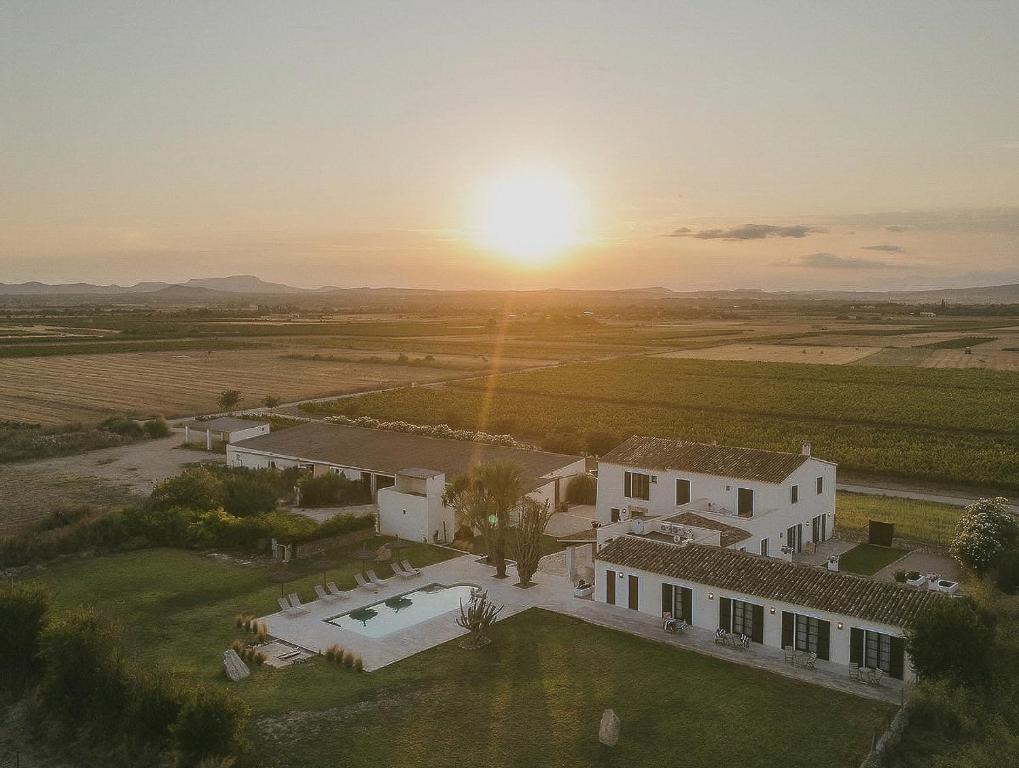 an aerial view of a house with the sunset in the background at Vino Resort Son Amaret in Son Macia