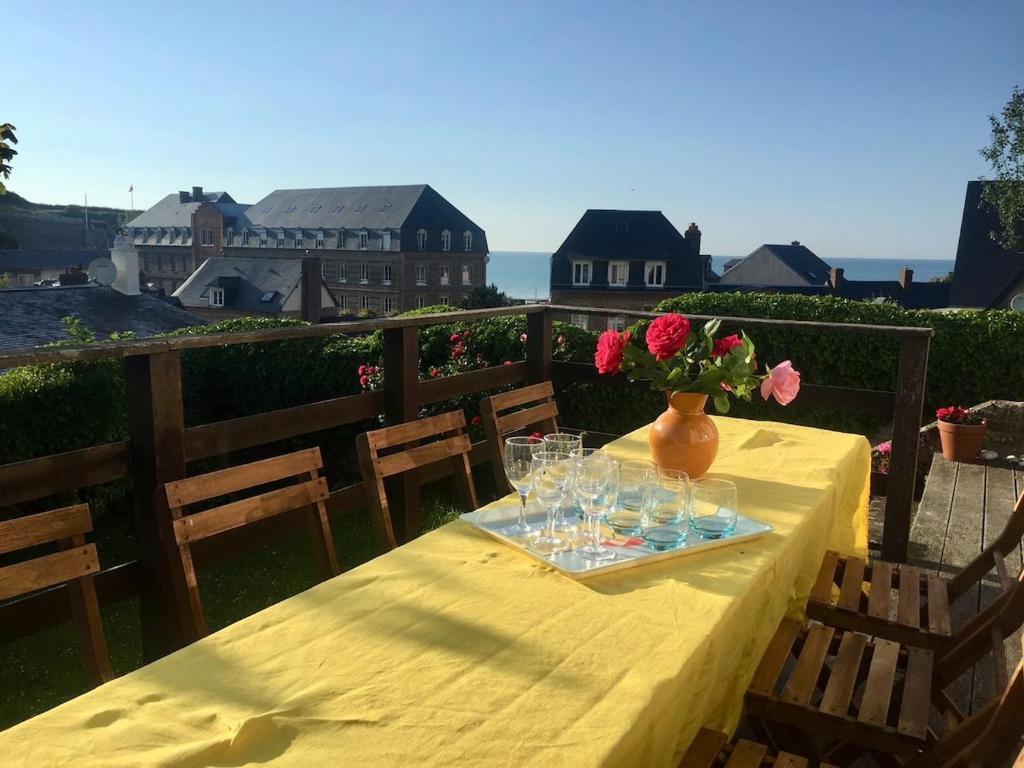 a yellow table with glasses and a vase with flowers on it at Villa Tournevent - Villa d'exception avec vue Mer - Veules-les-Roses in Veules-les-Roses
