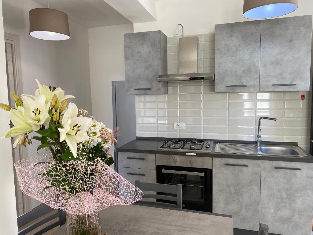 a kitchen with a vase of flowers on a table at Apartmán Sole Vita u moře in Isca Marina