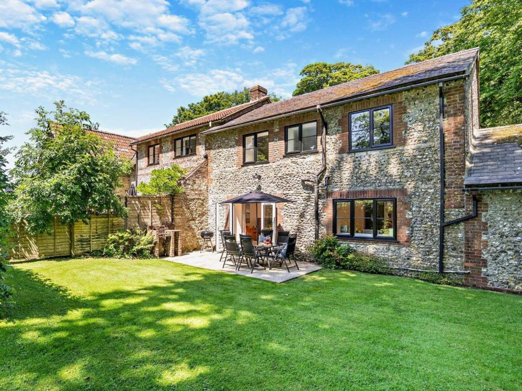 an exterior view of a stone house with a lawn at 4 Bed in Dorchester oc-92413 in Frome Vauchurch
