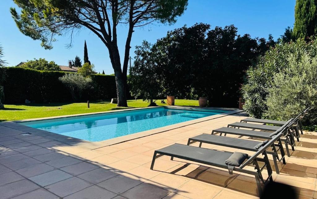 a swimming pool with two lounge chairs next to it at Mas de la Meï in Cavaillon