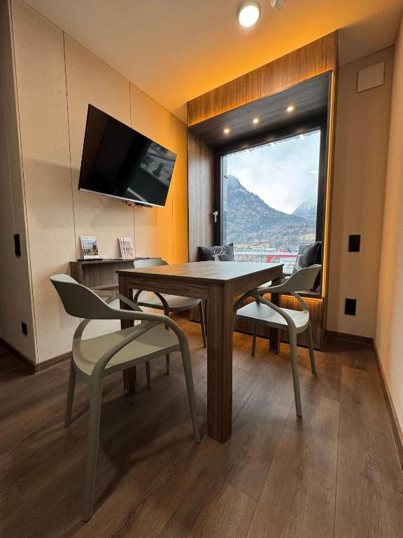 a room with a table and chairs and a large window at CUBE Alpine Stay in Bürs