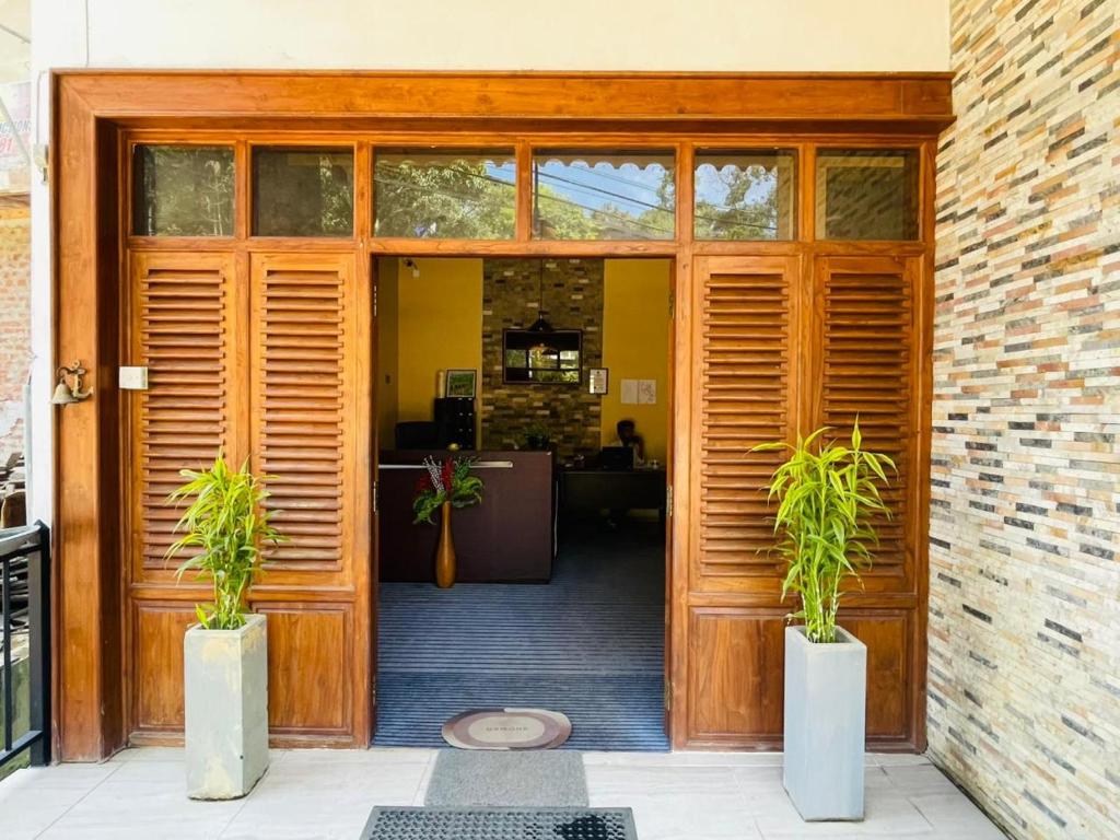 an open door with two potted plants in front of it at NAT City Ella in Ella