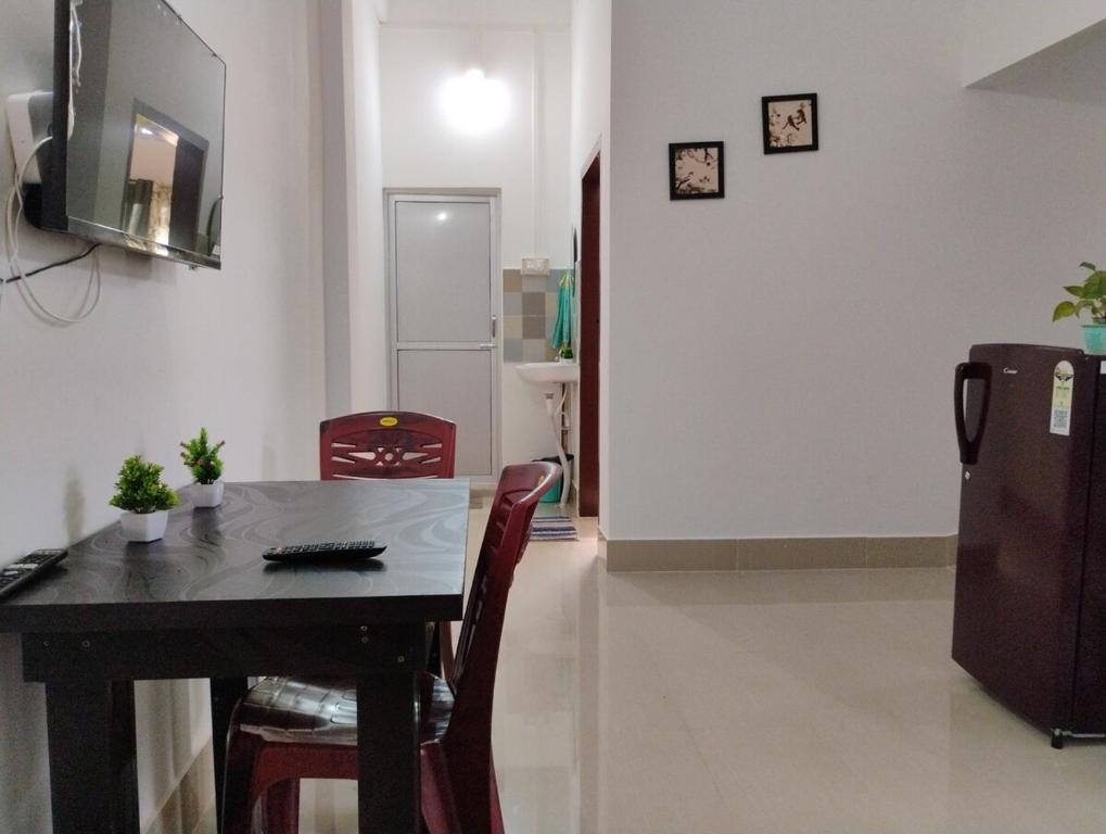 a dining room with a table and a refrigerator at Pranalay HS Warm and Cozy in Tezpur